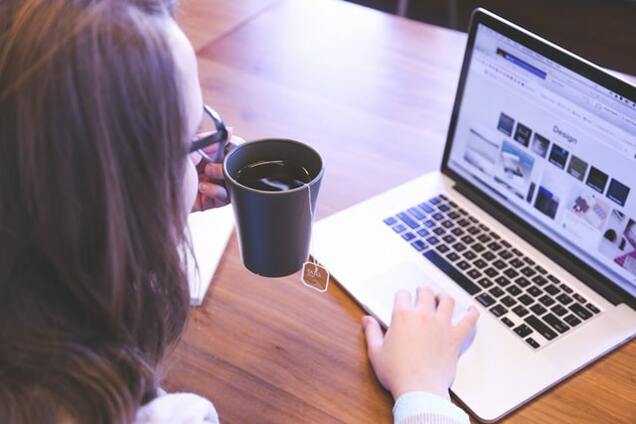 woman browsing web while drinking tea