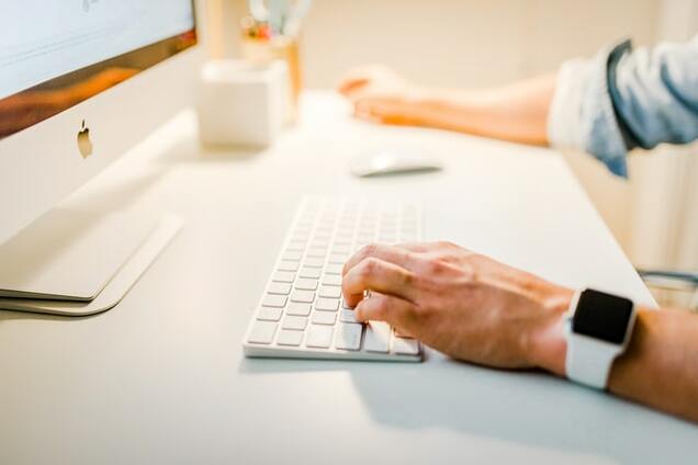 man typing on desktop keyboard