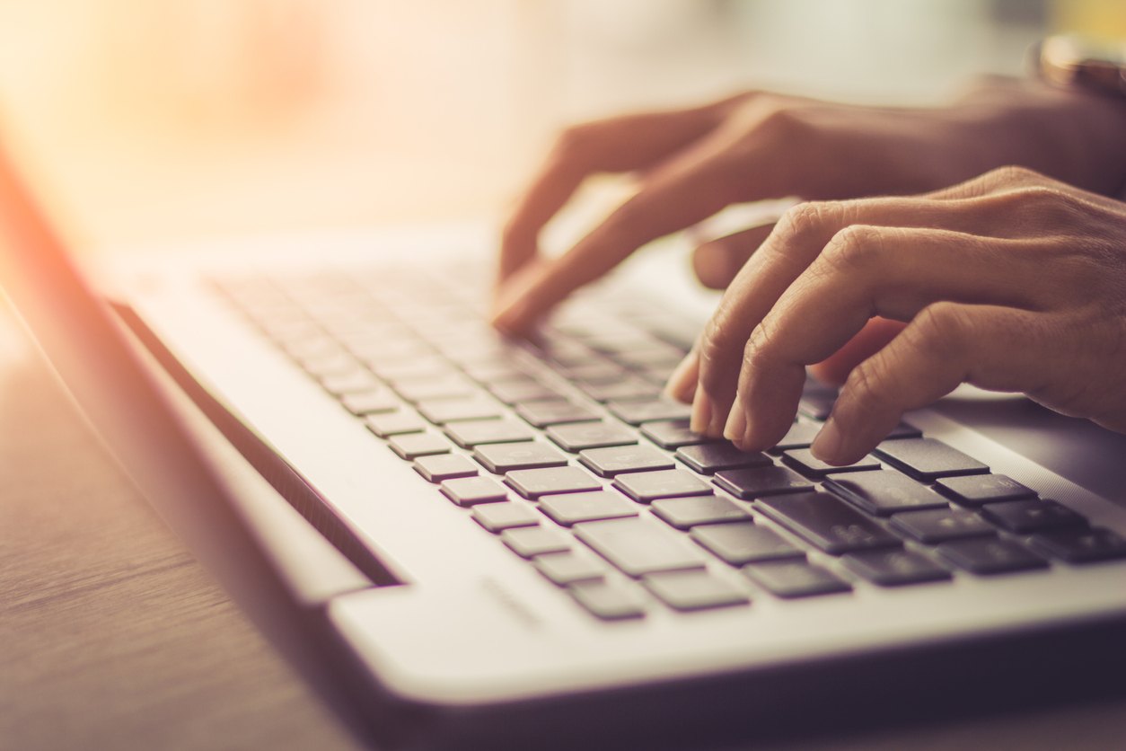 hands typing on a laptop