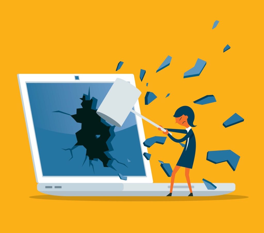 Woman smashing computer with a hammer